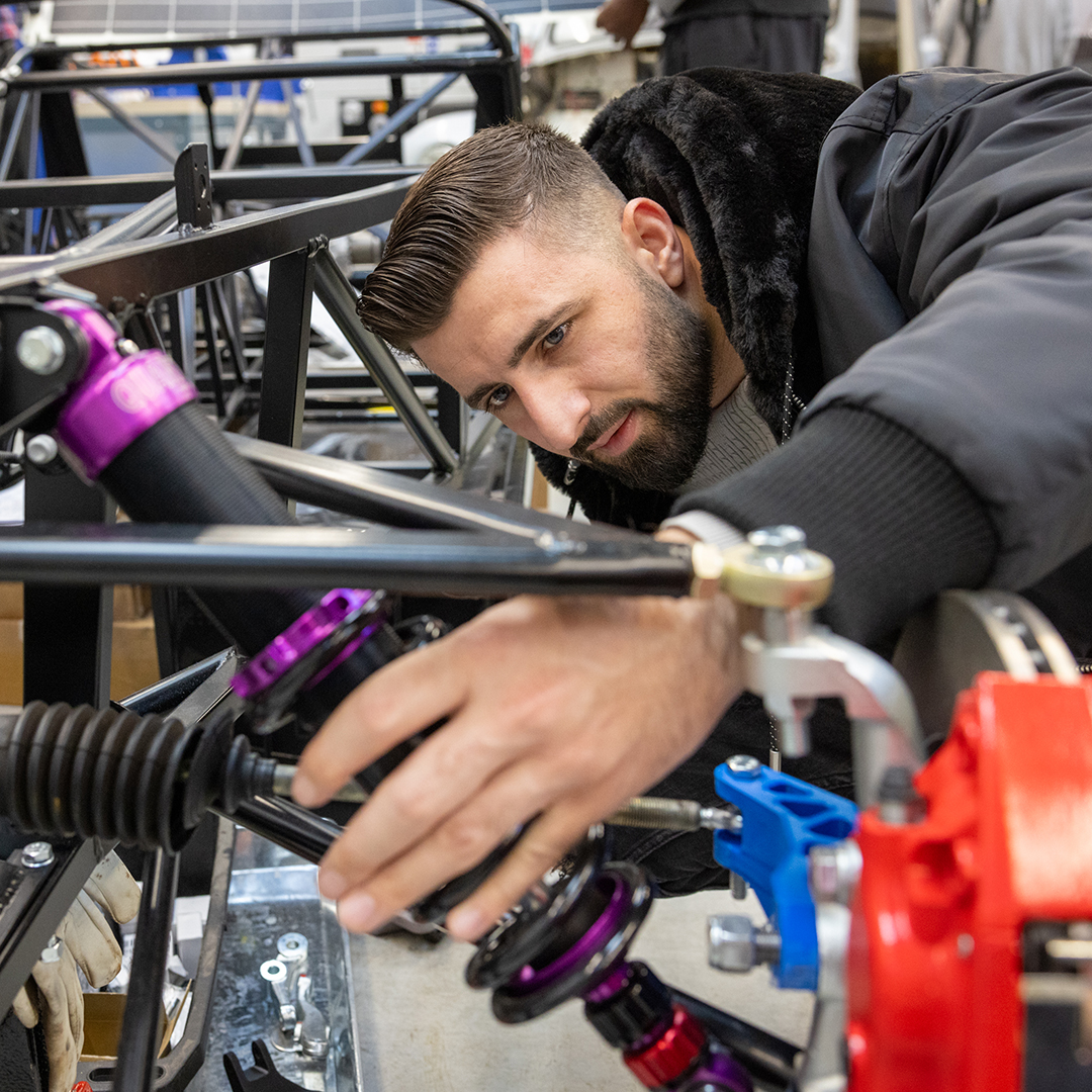 Uxbridge engineering student looking at the workings of a vehicle